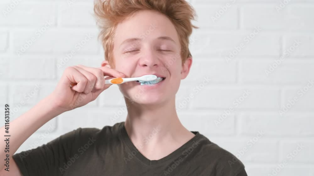 Portrait smiling red haired teen boy with toothbrush. Teenager kid brushing teeth on white background. Health care, dental hygiene. Portrait smiling red haired teen boy with toothbrush. Teenager kid brushing teeth on white background. Health care, dental hygiene.