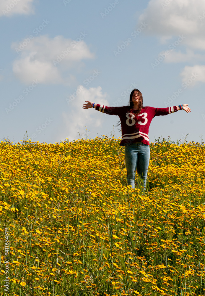 Happy girl and a field with yellow flowers in spring Happy girl and a field with yellow flowers in spring