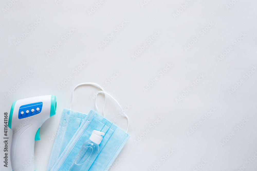Coronavirus protection concept flat lay. Disposable face masks and hand sanitizer on white background with copy space Coronavirus protection concept flat lay. Disposable face masks and hand sanitizer on white background with copy space