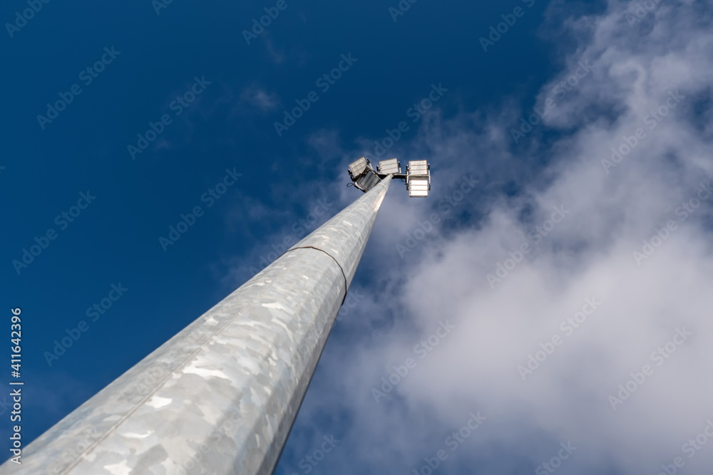 Powerful LED light on a aluminum metal pole , cloudy sky background. Concept sport event, game. Modern light source