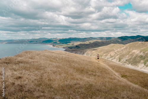 Girl running among hills in Castle Rock, New Zealand