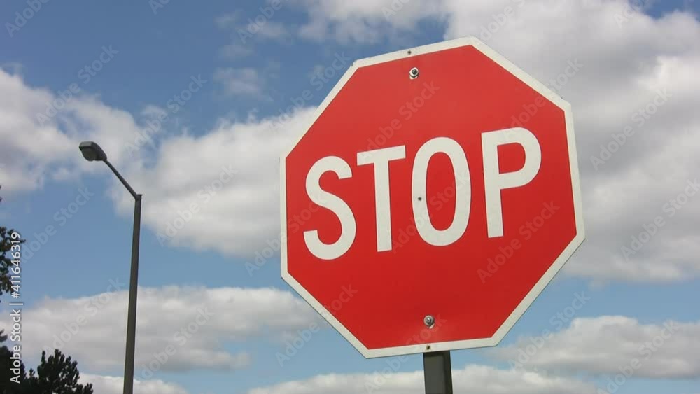 Stop sign with time lapse clouds. Red sign with blue and white clouds. Stop sign with time lapse clouds. Red sign with blue and white clouds.