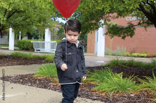alone and sad kid with a red ballon