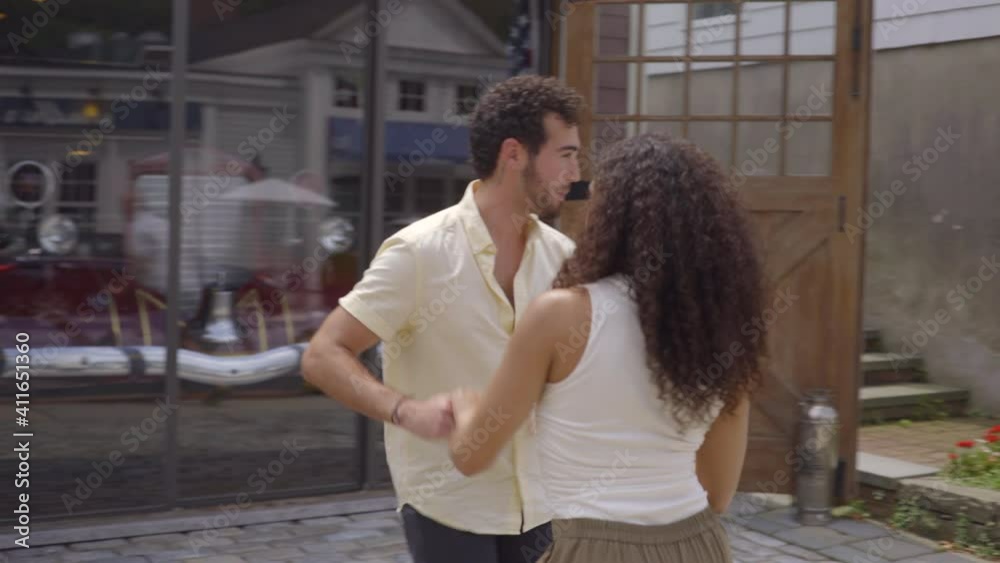 Panning Around a Happy Young Man and Woman Salsa Dancing on the Sidewalk