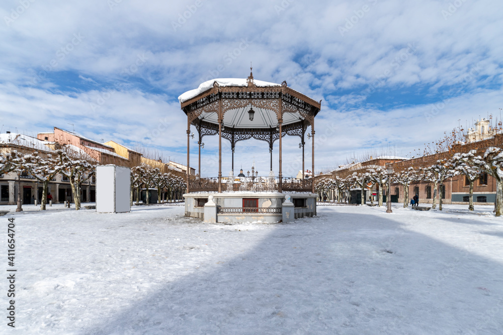 Cervantes square in the city of alcala de henares covered in snow with the bandstand in the foreground