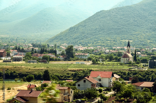 Typical Croatian village of Herzegovina with a catholic church on the Neretva river in a valley near the city of Mostar  Bosnia and Herzegovina . Neretva is a major river of Balkans