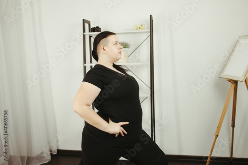 Overweight woman exercising in her living room