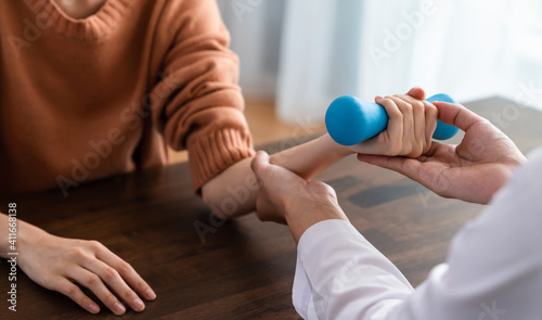 The doctor performed hand physical therapy for the patient with dumbbells.