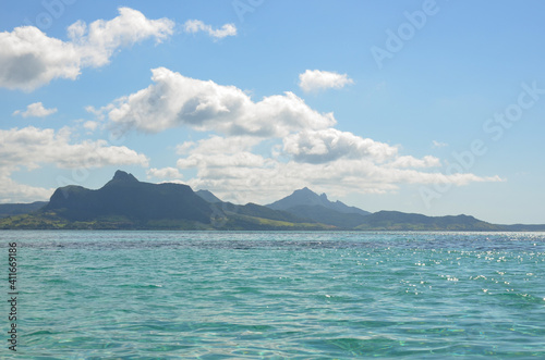 Turquoise Indian Ocean waters, mountains and blue sky on the east coast of Mauritius
