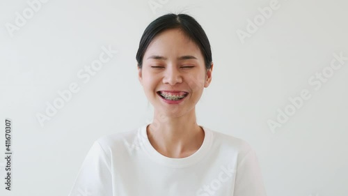 Asian women slowly smiled and laughed happily. A girl wearing braces.