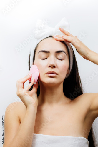 happy woman using electric cleansing brush for face deep cleaning. Beautiful naked woman clean face with cleansing brush. 
