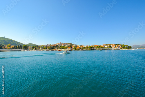 A small motorboat cruises along the Dalmatian Coast of Dubrovnik, Croatia, on the Adriatic Sea.