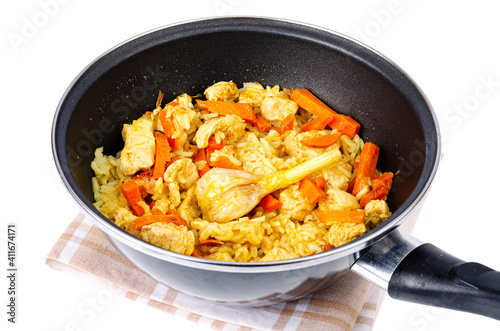 Pilaf. Rice with meat and vegetables in frying pan on white background. Studio Photo