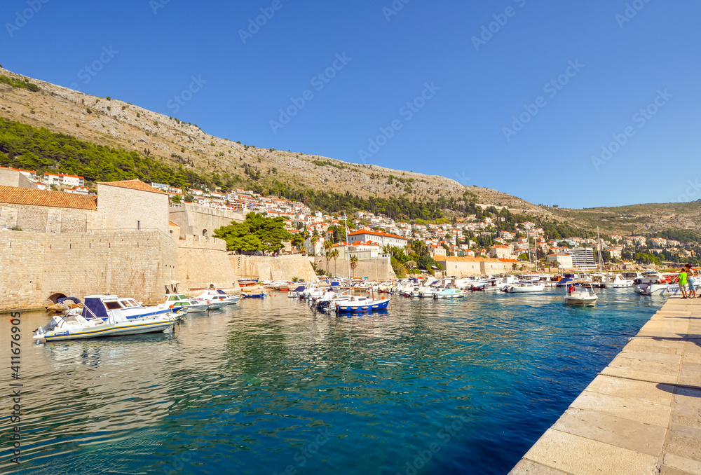 Boats in the harbor at the ancient walled city of Dubrovnik, Croatia on a sunny autumn afternoon on the Dalmatian Coast.