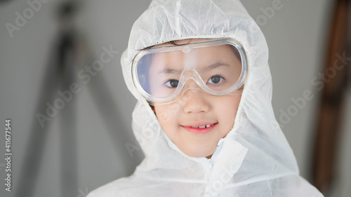 Portrait confident Asian kid in protective PPE suit wearing eyeglasses