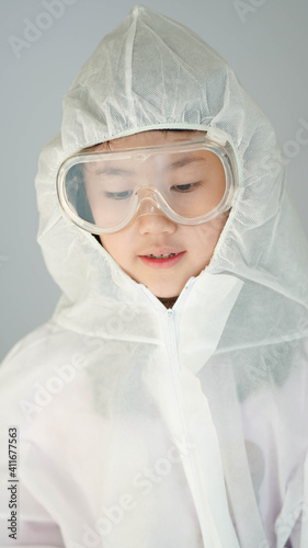 Portrait confident Asian kid in protective PPE suit wearing eyeglasses