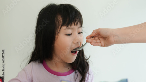 mom feeding child daughter food.