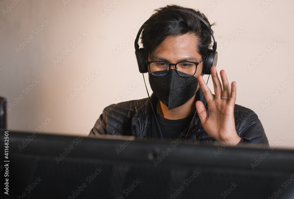 young man working with computer from his quarantined office young man working with computer from his quarantined office