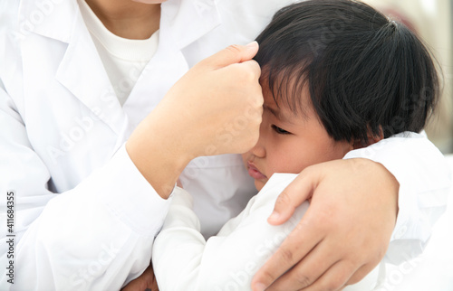 The woman doctor is comforting the child patient
