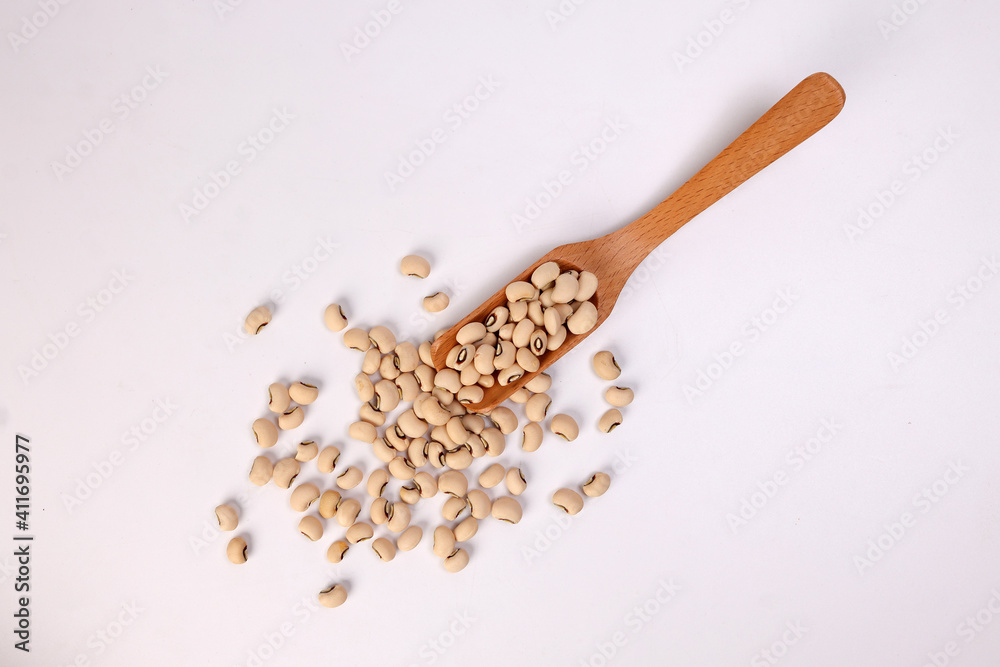 Blackeye beans in wooden scoop spoon top view on white background Blackeye beans in wooden scoop spoon top view on white background