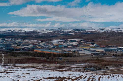 Panorama of an industrial plant in the mountains in winter. Working materials containers are located in the middle of natural surroundings.