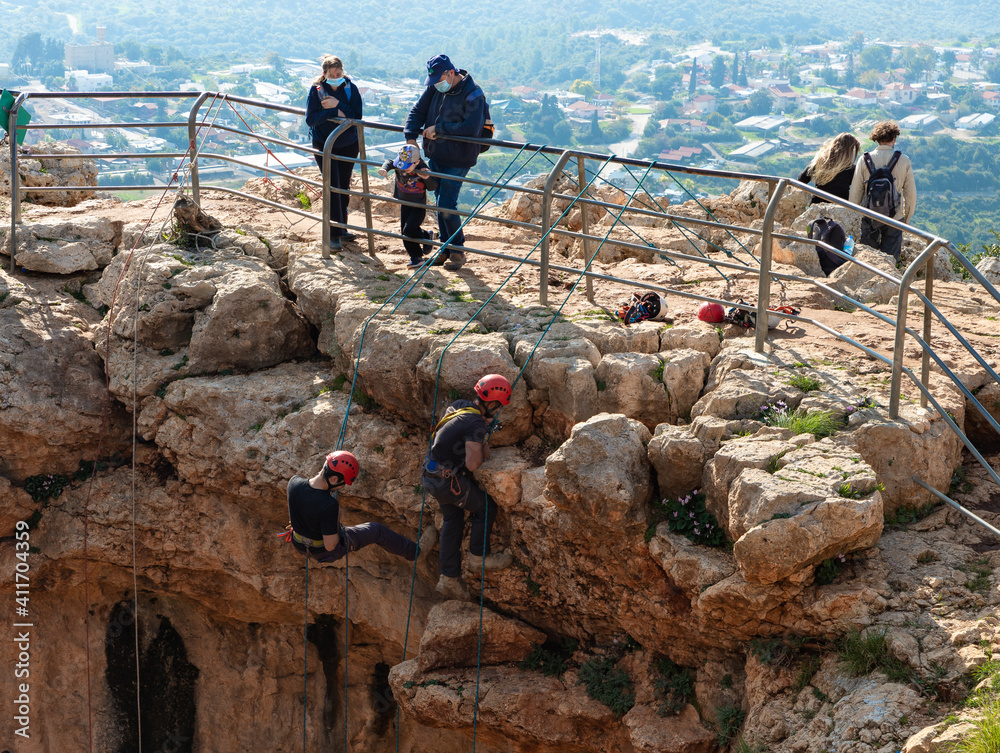 Two athletes begin the descent on a rope down climbing snapping