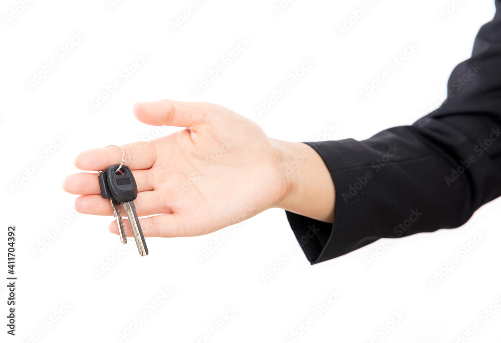 In front of the white background, one hand holds the door key In front of the white background, one hand holds the door key