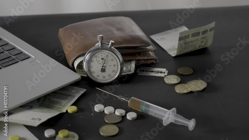 Stopwatch with money and drugs on a black table