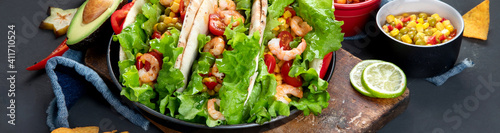 Hispanic mexican food, meat tacos with shrimps on dark background