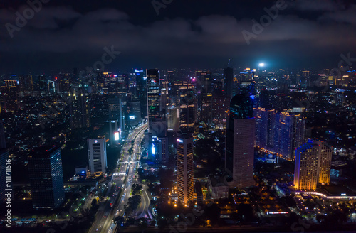 Modern metropolitan city center with skyscrapers at night City lights and highway traffic in Jakarta, Indonesia in the dark © 21AERIALS