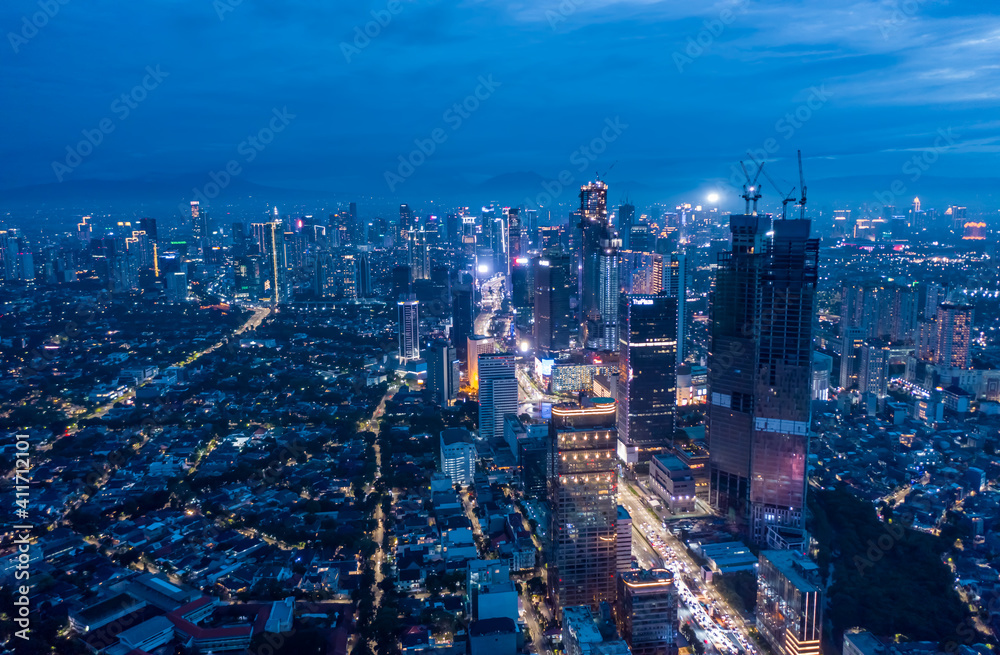Aerial wide panoramic view of modern cityscape with high rises in the night Skyscrapers and residential neighborhoods in blue night light in Jakarta, Indonesia