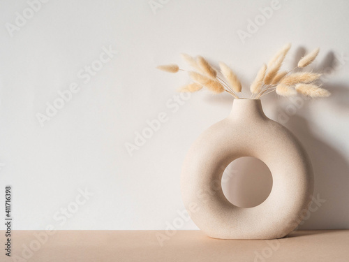 Round stylish ceramic vase with dried flower lagurus