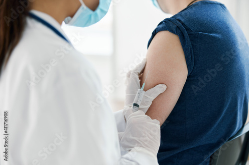 woman doctor nurse in protective gloves and coronavirus vaccine injection epidemic