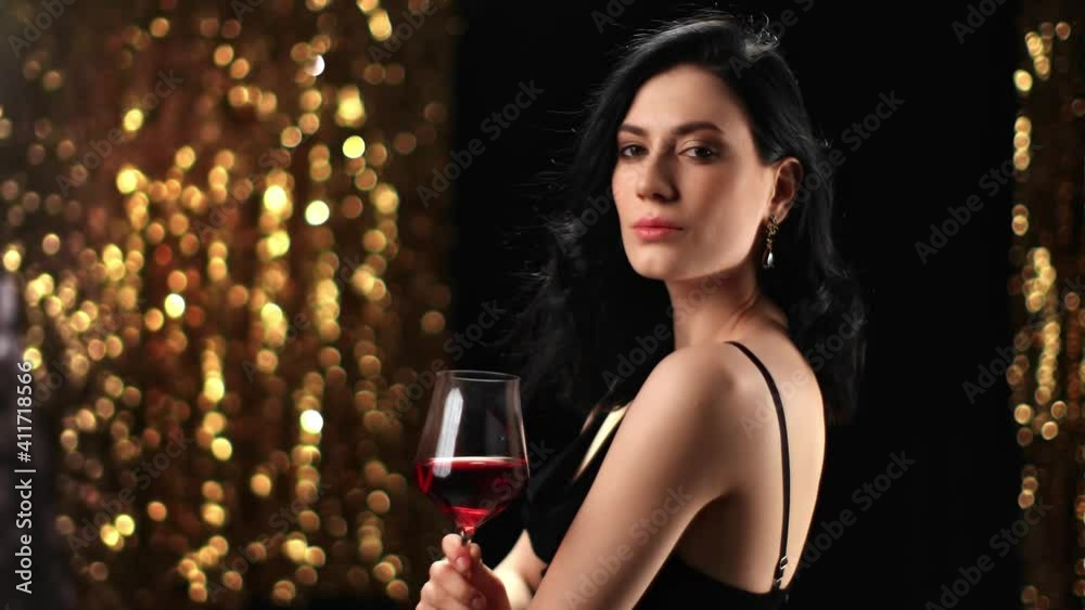 Fashionable lady posing with red wine at golden flash bokeh. Shot on RED Raven 4k Cinema Camera Fashionable lady posing with red wine at golden flash bokeh. Shot on RED Raven 4k Cinema Camera