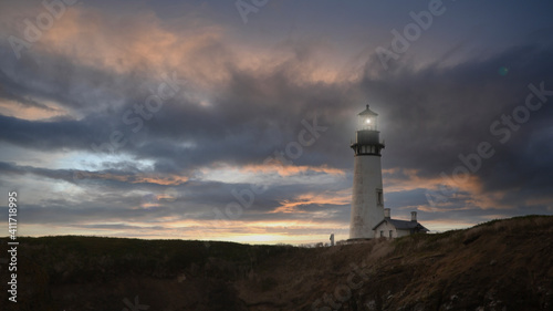 Yaquina Head Lighthouse built in 1873, with dramatic sunset, dark foreground - Oregon, USA