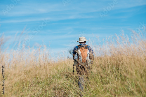 young man standing in a grassy field Bright blue sky