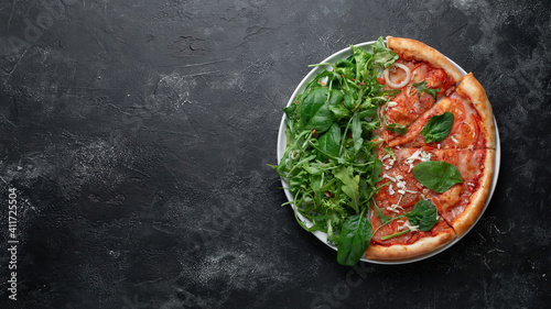 Tasty appetizing vegetarian pizza on dark stone background, top view 