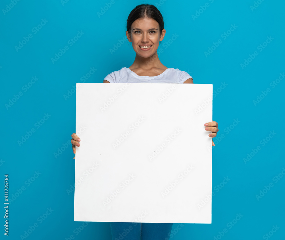 happy casual woman presenting her billboard at the camera happy casual woman presenting her billboard at the camera