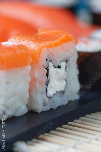 Sushi rolls with salmon, rice, greens and soy sauce