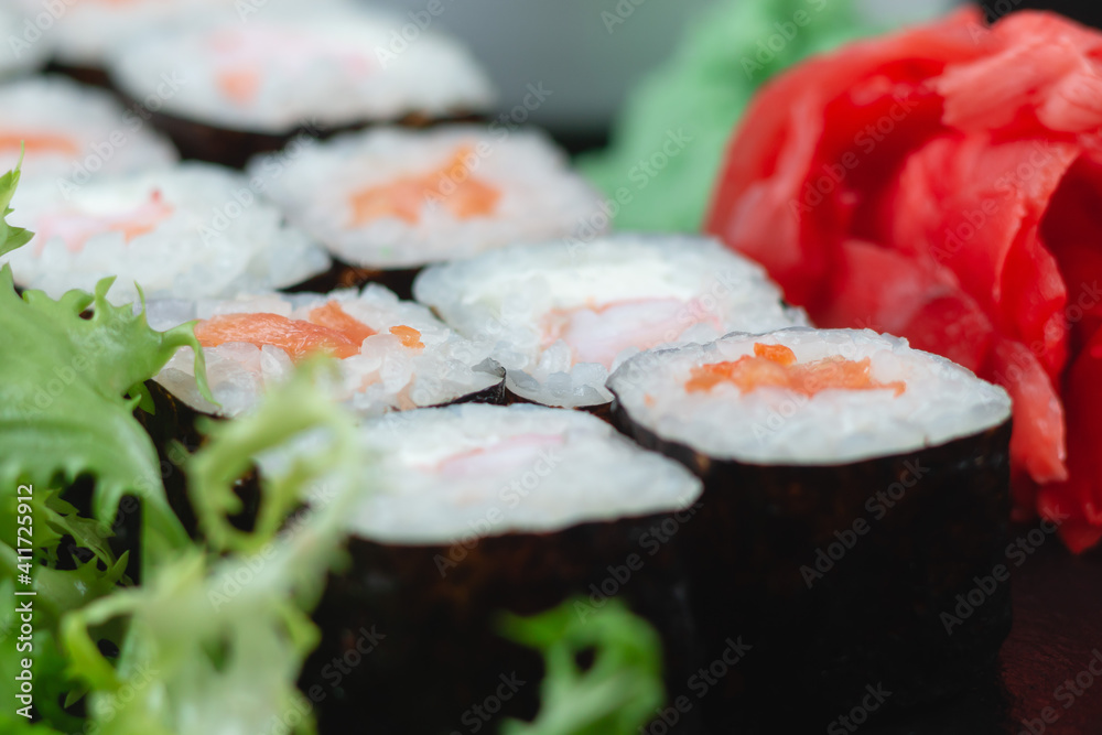 Sushi rolls with salmon, rice, eel and soy sauce on dark stone background Sushi rolls with salmon, rice, eel and soy sauce on dark stone background