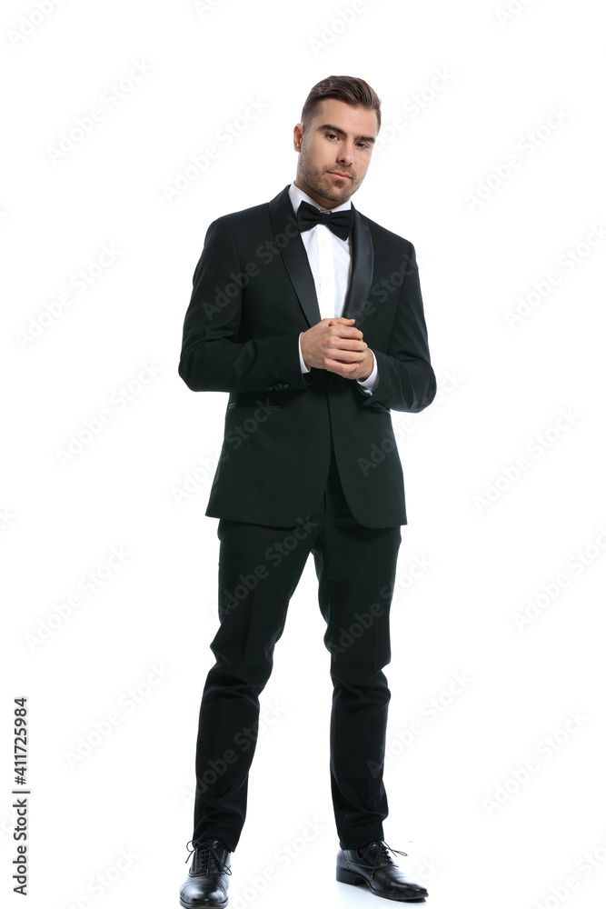 full body picture of elegant young businessman holding hands