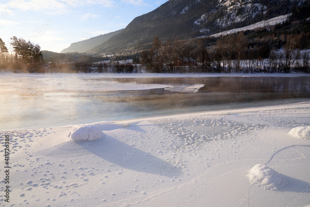 The river is about to freeze. It is very cold and the river is much warmer than the air, therefore the smoke or the damp from the river. Shot at Gol, Norway in February. Minus 20 degreases Celsius. The river is about to freeze. It is very cold and the river is much warmer than the air, therefore the smoke or the damp from the river. Shot at Gol, Norway in February. Minus 20 degreases Celsius.
