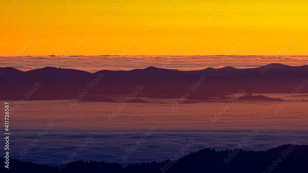 The sun's rays illuminate the mountain tops and the fog at dawn. The sun's rays illuminate the mountain tops and the fog at dawn.