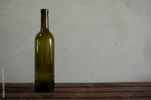 empty wine bottle on gray background and wooden table
