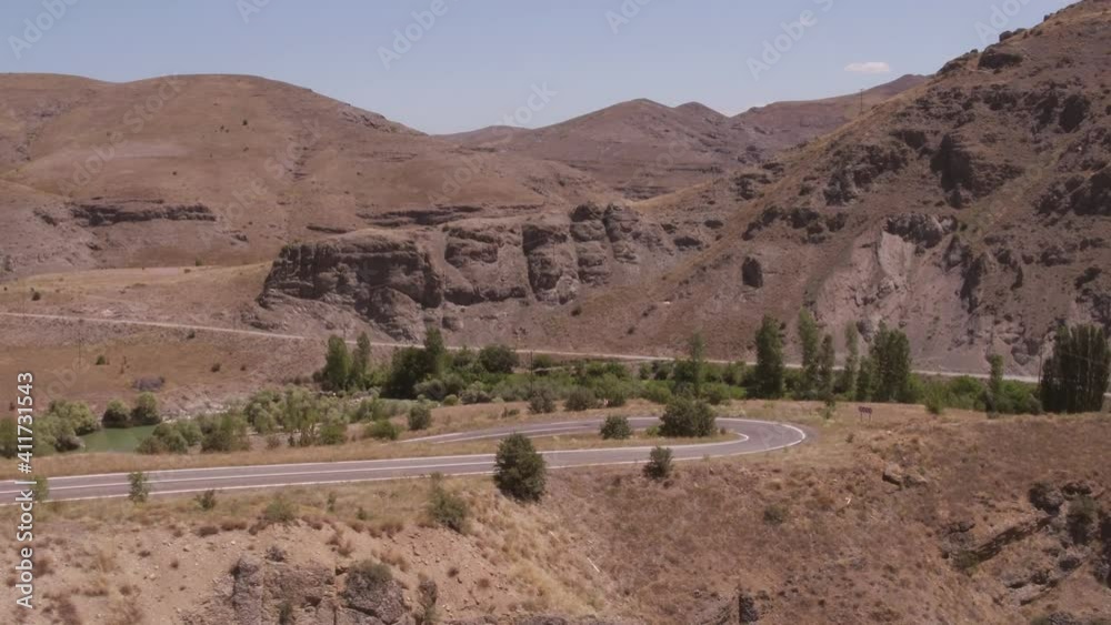 Empty winding asphalt road. Turkish winding highway through arid rocky mountains at summer sunny day. Aerial drone view. Empty winding asphalt road. Turkish winding highway through arid rocky mountains at summer sunny day. Aerial drone view.