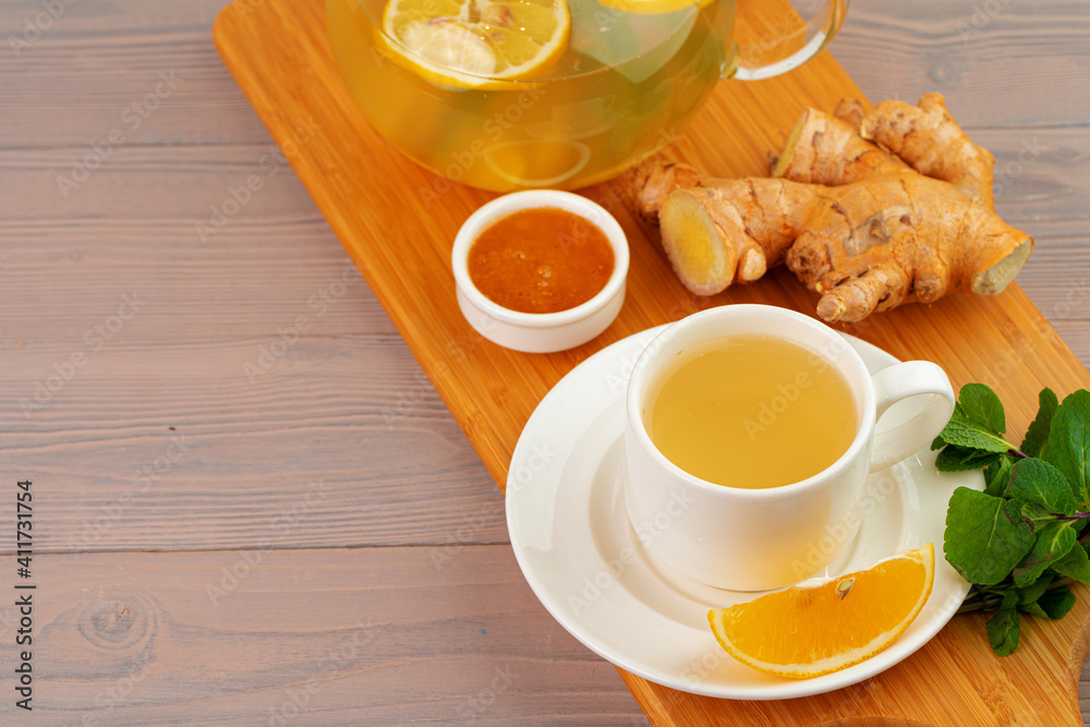 Cup of tea with ginger and mint on wooden table Cup of tea with ginger and mint on wooden table