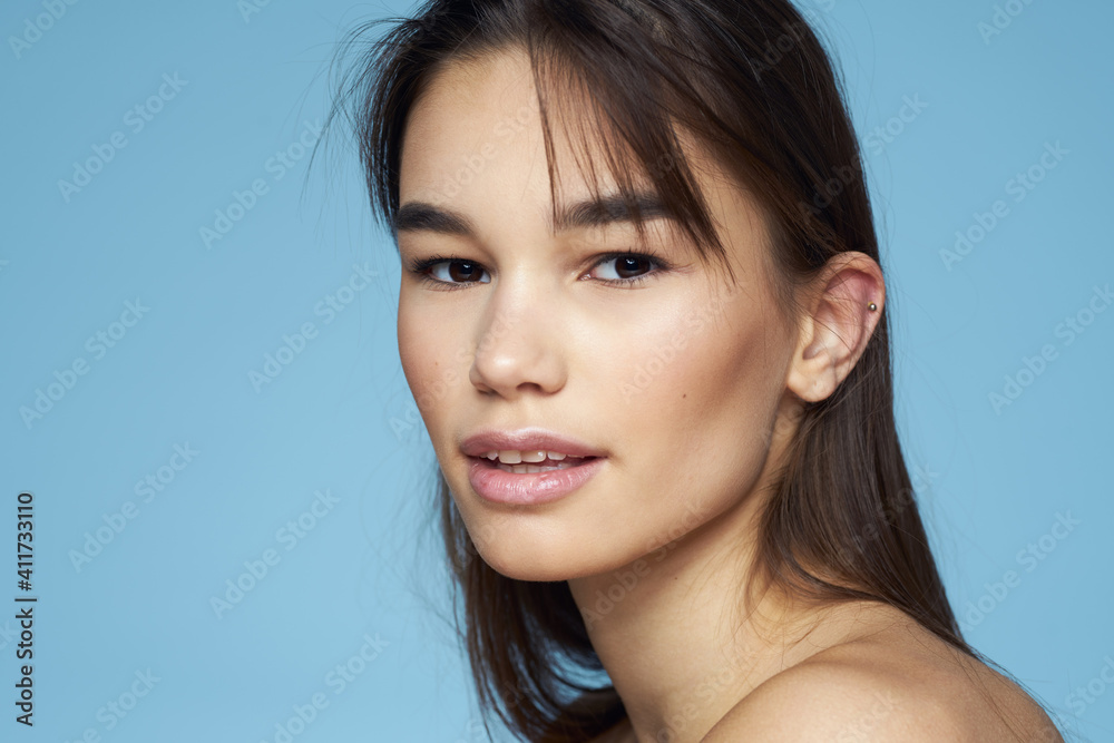 Pretty woman naked shoulders hair care close-up bank blue background Pretty woman naked shoulders hair care close-up bank blue background
