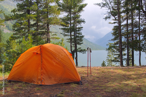A tourist tent stands in the mountains near the lake.