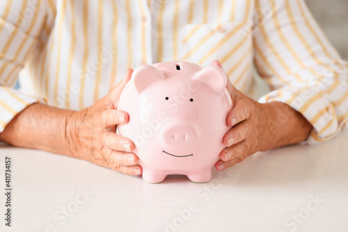 Senior woman with piggy ban...