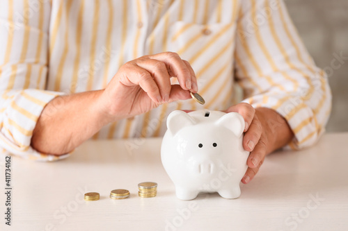 Senior woman putting coin i...